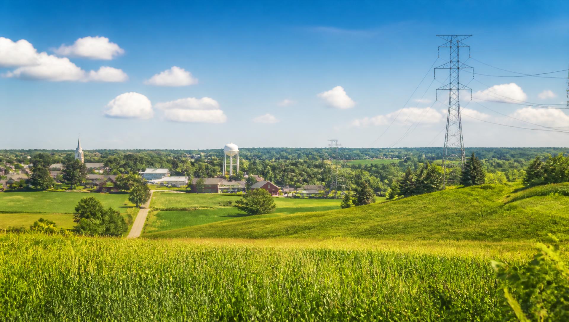 Sunny Ohio farmland with a small town and transmission lines